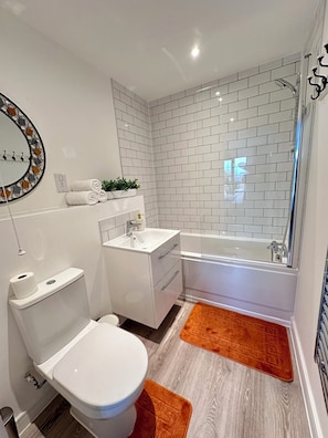 Ein modernes Badezimmer mit Toilette, Waschbecken und Badewanne.