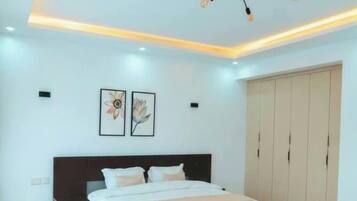 A bedroom with a bed, bedside tables, a wardrobe, and a ceiling light fixture.