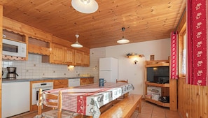 Un intérieur en bois comprenant une cuisine, une table à manger et un banc.