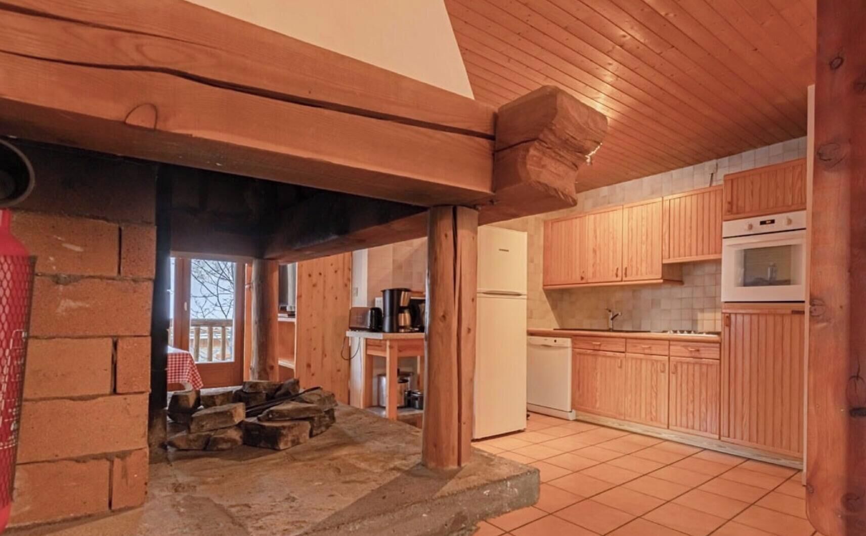Una cucina rustica con mobili in legno, un frigorifero e un fornello.