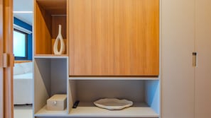 Een slaapkamer met een bed, nachtkastje, en een kledingkast met spiegel.