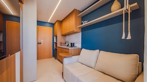 A compact kitchenette with wooden cabinets, a countertop, and a built-in oven. - Apt w/ Pool & Gym, 800m from Armação Beach  Espanhol: (Salvador)