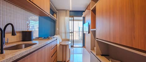 Una cocina moderna con armarios de madera, un lavamanos y una pequeña mesa redonda.