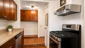 A kitchen with wooden cabinets, a stainless steel range, and a black stove.