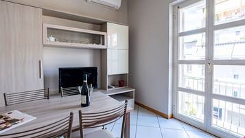 Una cocina moderna con comedor, televisor y un amplio ventanal.
