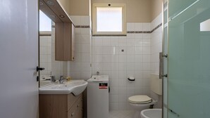 Un baño pequeño con lavamanos, espejo e inodoro.