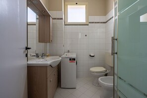 Een kleine badkamer met een wastafel, spiegel en toilet.