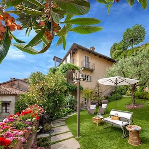 A residential property with a well-maintained garden, outdoor seating, and a two-story house with balconies. - Luisa Smile - Two Bedroom Villa, Sleeps 6 (Guarene)