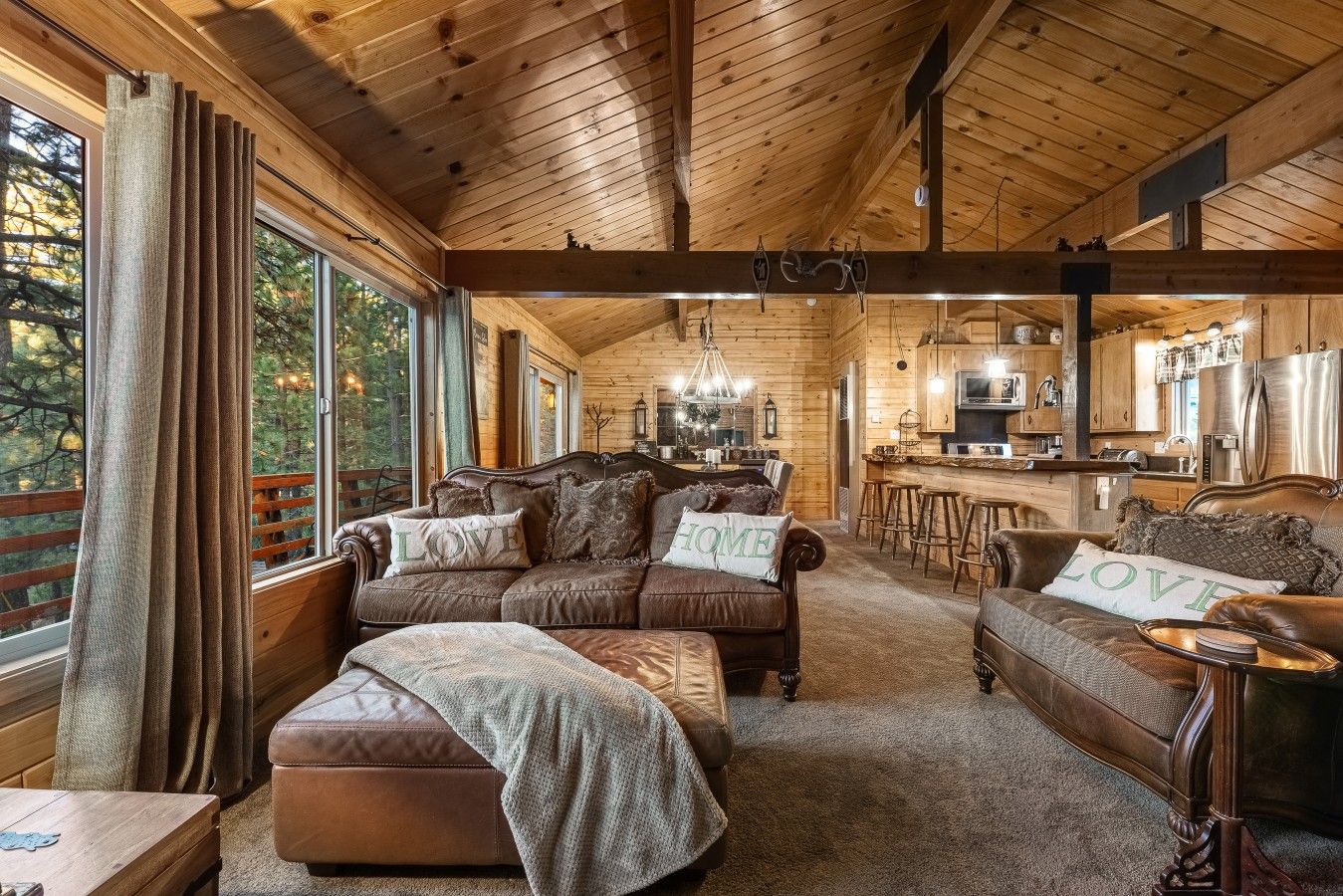 L'intérieur d'un chalet confortable en bois, avec un salon, une cuisine et un coin bar.