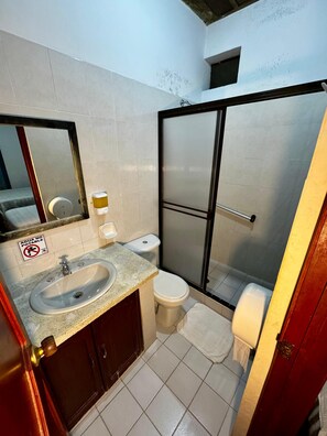 Ein kleines Badezimmer mit Waschbecken, Toilette und Dusche.