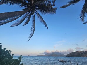 Cielo despejado con vista al mar y montañas a lo lejos.
