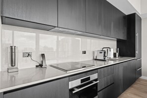 A modern kitchen with a sleek countertop, integrated appliances, and a built-in oven. - Luxury E11EVEN Skyline Views & ELITE Amenities (Miami)