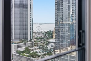 A high-rise building with a view of a Ferris wheel and water in the background. - Luxury E11EVEN Suite with Amazing Pool & Views (Miami)