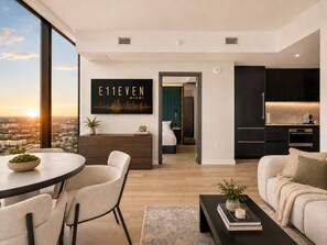 A modern living room with a dining area, a sofa, a coffee table, and a view of the city skyline. - 23rd Floor E11EVEN 1BR with Balcony & Views (Miami)