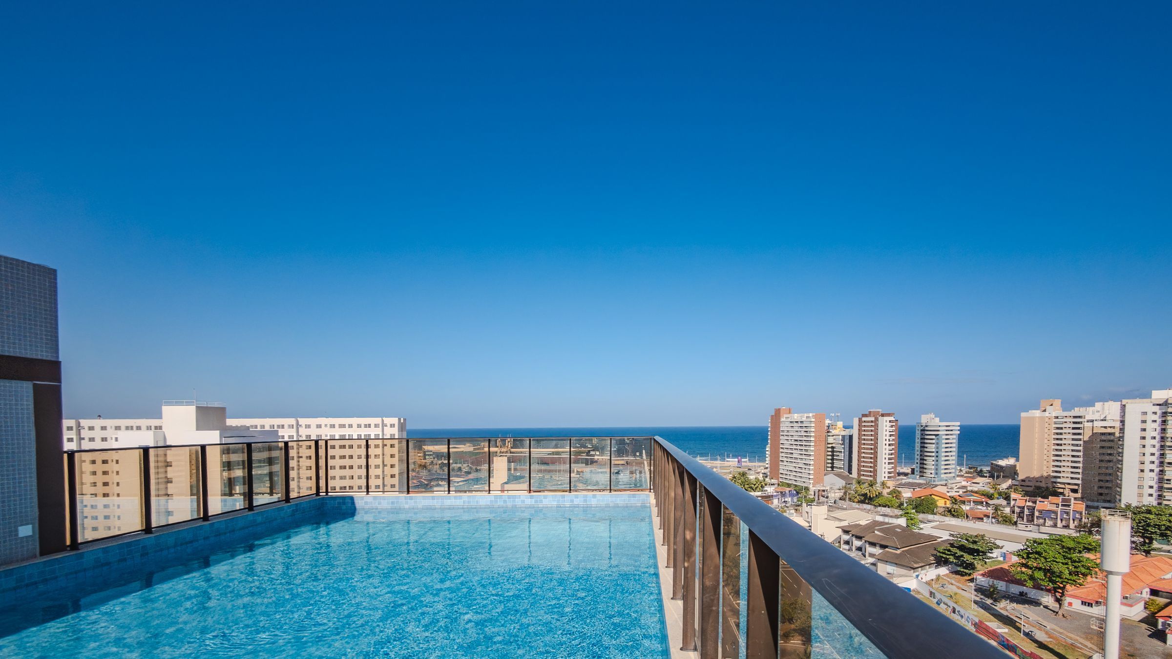 A rooftop pool with a city view, surrounded by high-rise buildings.