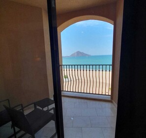 Un balcó amb vista a una platja i una muntanya.