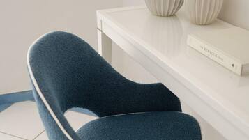 A chair with a dark fabric and metal frame, positioned on a tiled floor with blue and white tiles.