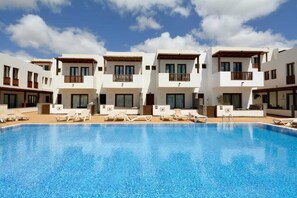 A modern hotel with a swimming pool, multiple balconies, and sun loungers. - Home2Book Bellavista Puerto Calero Pool & BBQ (Puerto Calero)