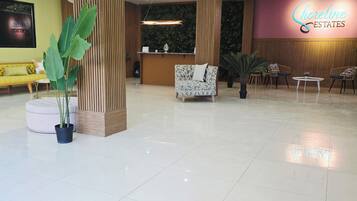 A reception area with a reception desk, seating arrangements, and a large potted plant.