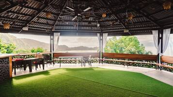 An outdoor seating area with a view of a mountainous landscape.