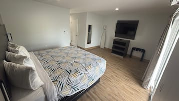 Ein Schlafzimmer mit einem Bett, einem Fernseher und einer Tür.