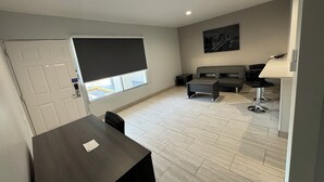 Ein modernes Wohnzimmer mit einer Couch, einem Couchtisch und einem Esstisch.