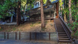 A multi-level wooden cabin with a staircase leading to a deck. - Wilderness Lodge by Avantstay Firepit Gazebo + Wraparound Decks Minutes to Village + Trails (Cedar Glen)