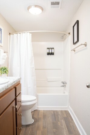 Un baño con inodoro, ducha y bañera.