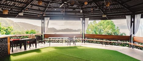 An outdoor seating area with a view of a mountainous landscape.