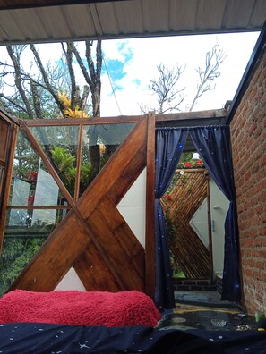 A room with a bed, a wooden partition, and a view of the outdoors. - Stargazing glamping, with a sliding roof and a jacuzzi, birdwatching (Puente Palo)