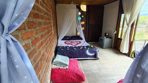Ein Schlafzimmer mit einem Bett, einem kleinen Tisch und einem Fenster.