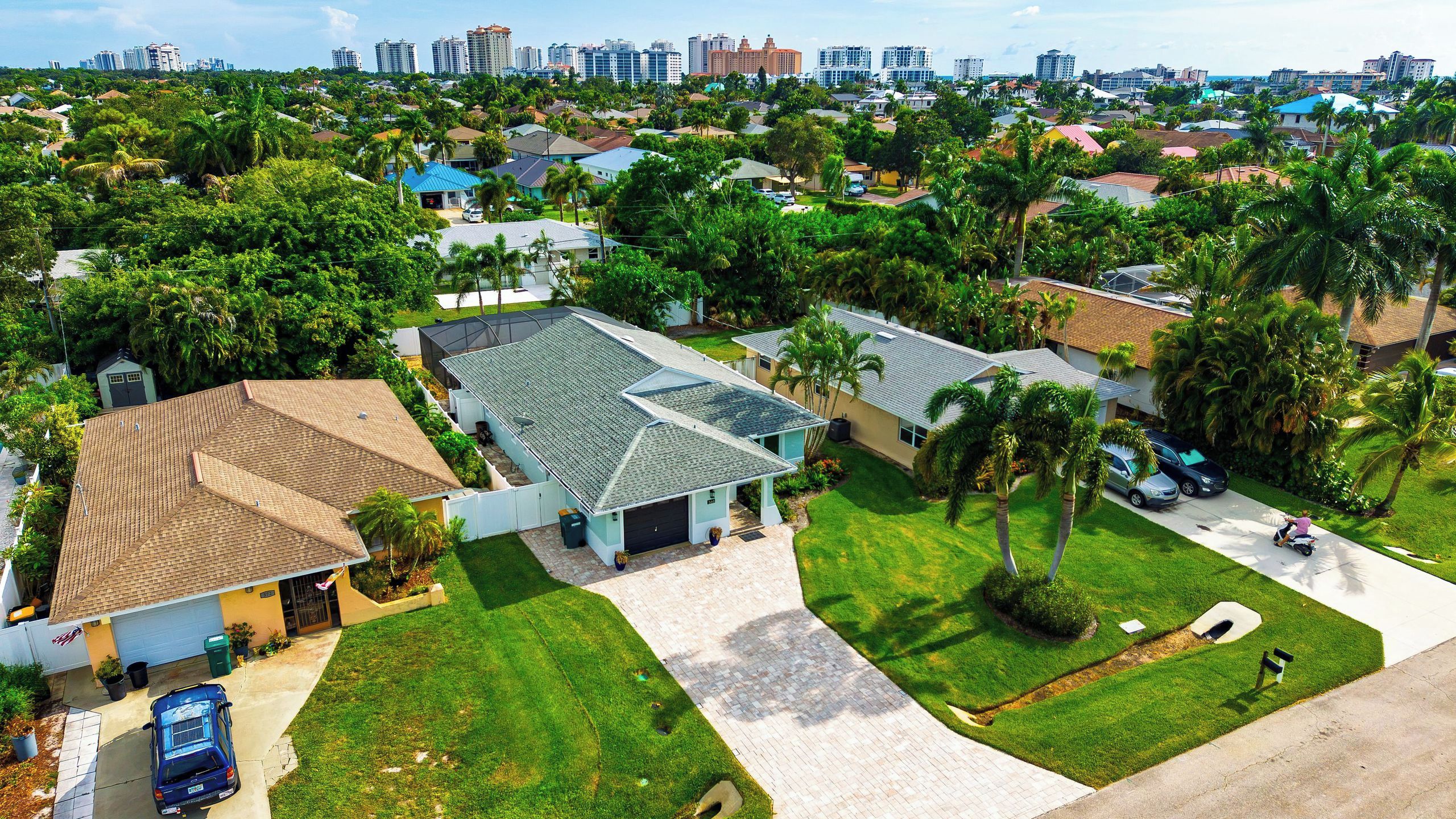 A residential area with houses, a clear sky, and a distant city skyline.