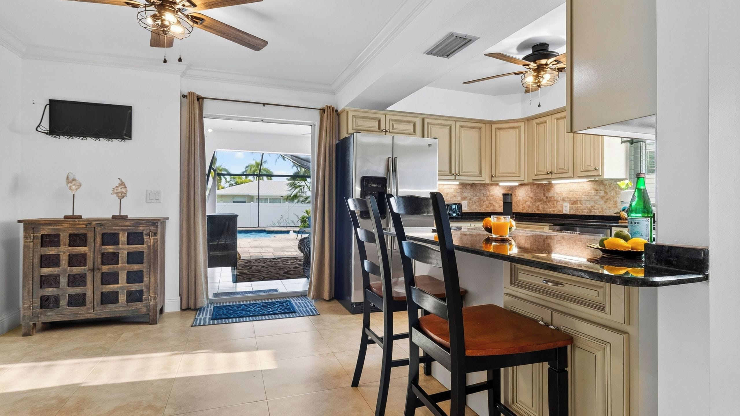 A kitchen with a dining area, a refrigerator, a coffee maker, and a bottle of water.