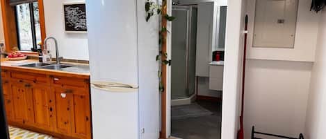 Une cuisine moderne avec un réfrigérateur blanc, des armoires en bois et une fenêtre donnant sur un beau paysage.