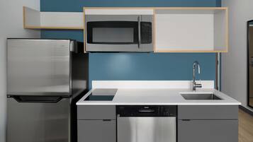 Una cocina moderna con un refrigerador de acero inoxidable, un microondas y un lavavajillas.