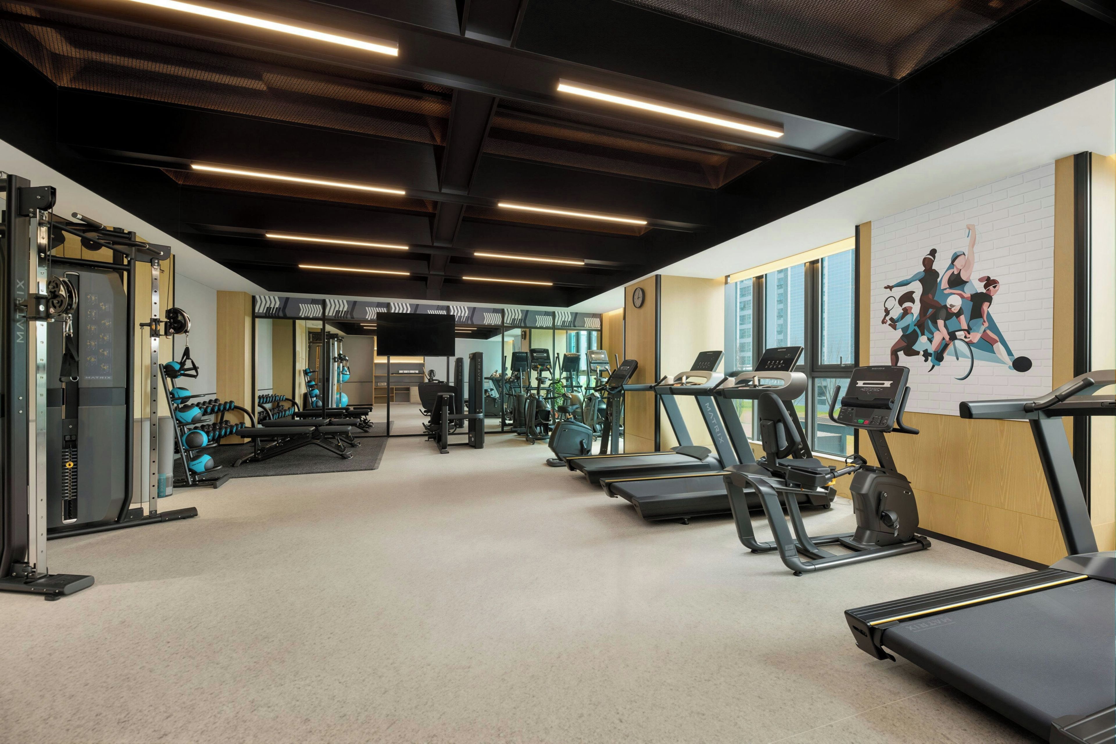 A gym with treadmills, weight machines, and exercise balls.