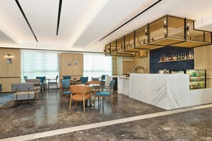A modern hotel lobby with a bar area, seating arrangements, and a reception desk. - Four Points By Sheraton Changsha South Station (Changsha)