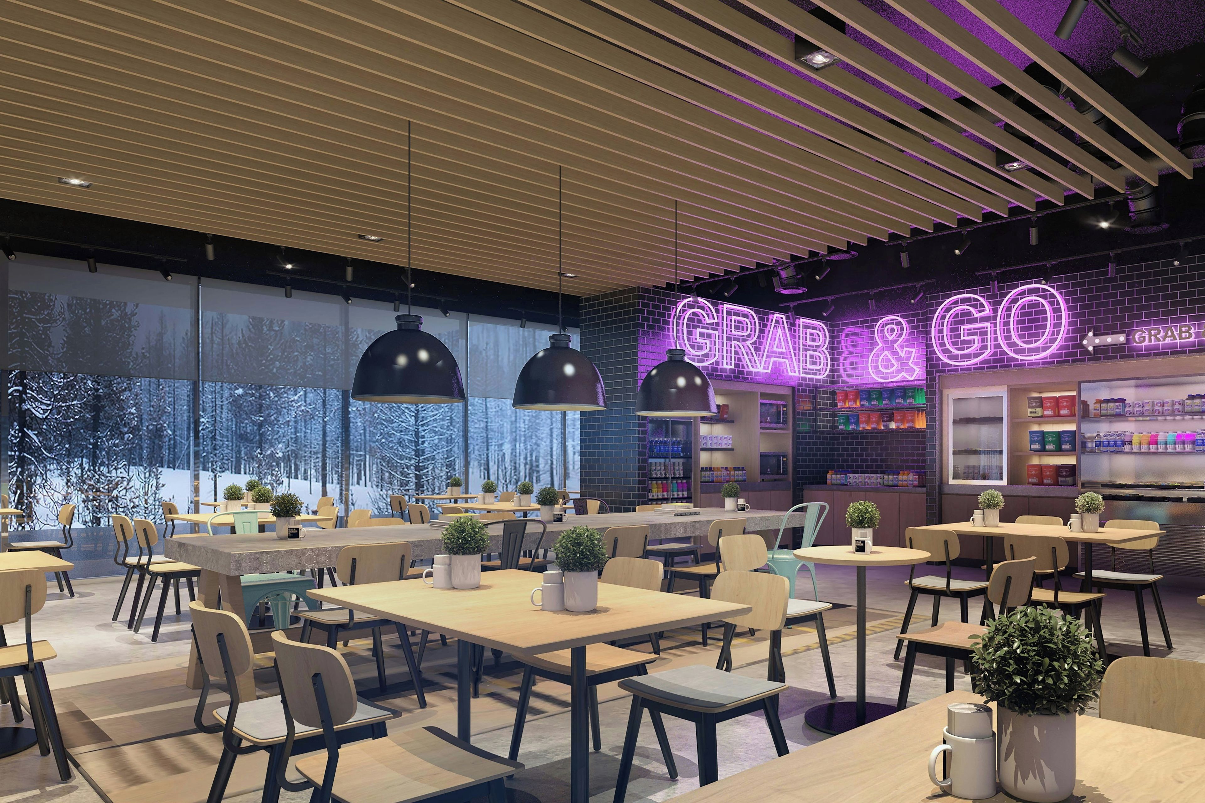 Interior moderno de una cafetería con mesas, sillas y un letrero de neón que dice 'GRAB & GO'.
