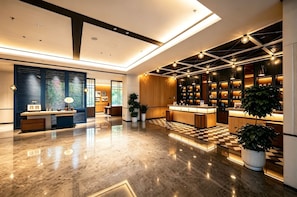 A modern hotel lobby with a checkered floor, a reception desk, and a bar area. - Four Points By Sheraton Zhangjiajie National Forest Park (Zhangjiajie)