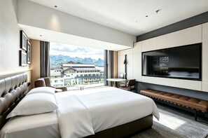 A modern hotel room with a large bed, a TV mounted on the wall, and a view of traditional buildings. - Four Points By Sheraton Zhangjiajie National Forest Park (Zhangjiajie)