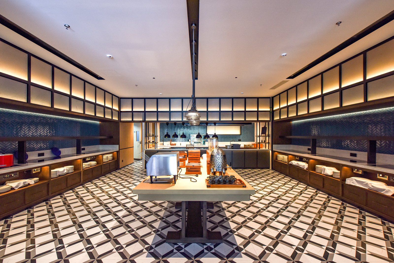 A modern interior with a central dining table, kitchen area, and seating on both sides.