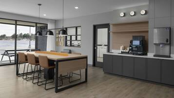 A modern kitchen with a dining area, built-in appliances, and a view through the window.