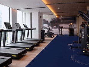 A gym with treadmills, exercise bikes, and weight machines.