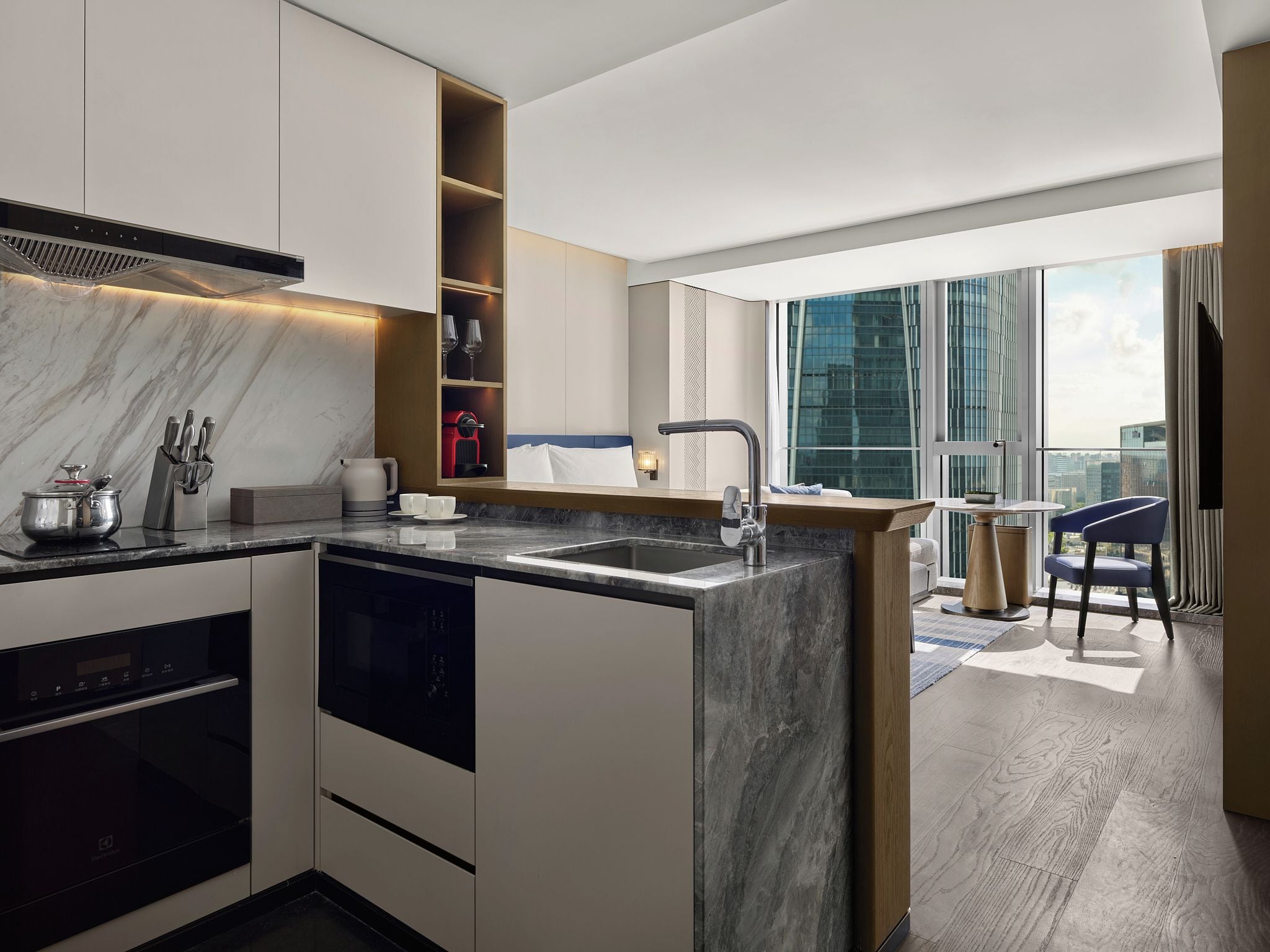 A modern kitchen with a built-in oven, a sink, and a coffee machine.