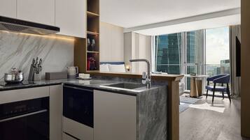 A modern kitchen with a built-in oven, a sink, and a coffee machine.