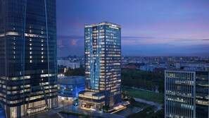 A high-rise building with multiple floors, large windows, and a well-lit facade.