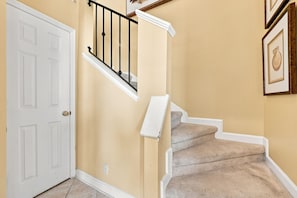 A staircase with a white handrail and a beige wall. - Oceanview Pool Beach Stay @Villa Capriani 3 Kings (North Topsail Beach)