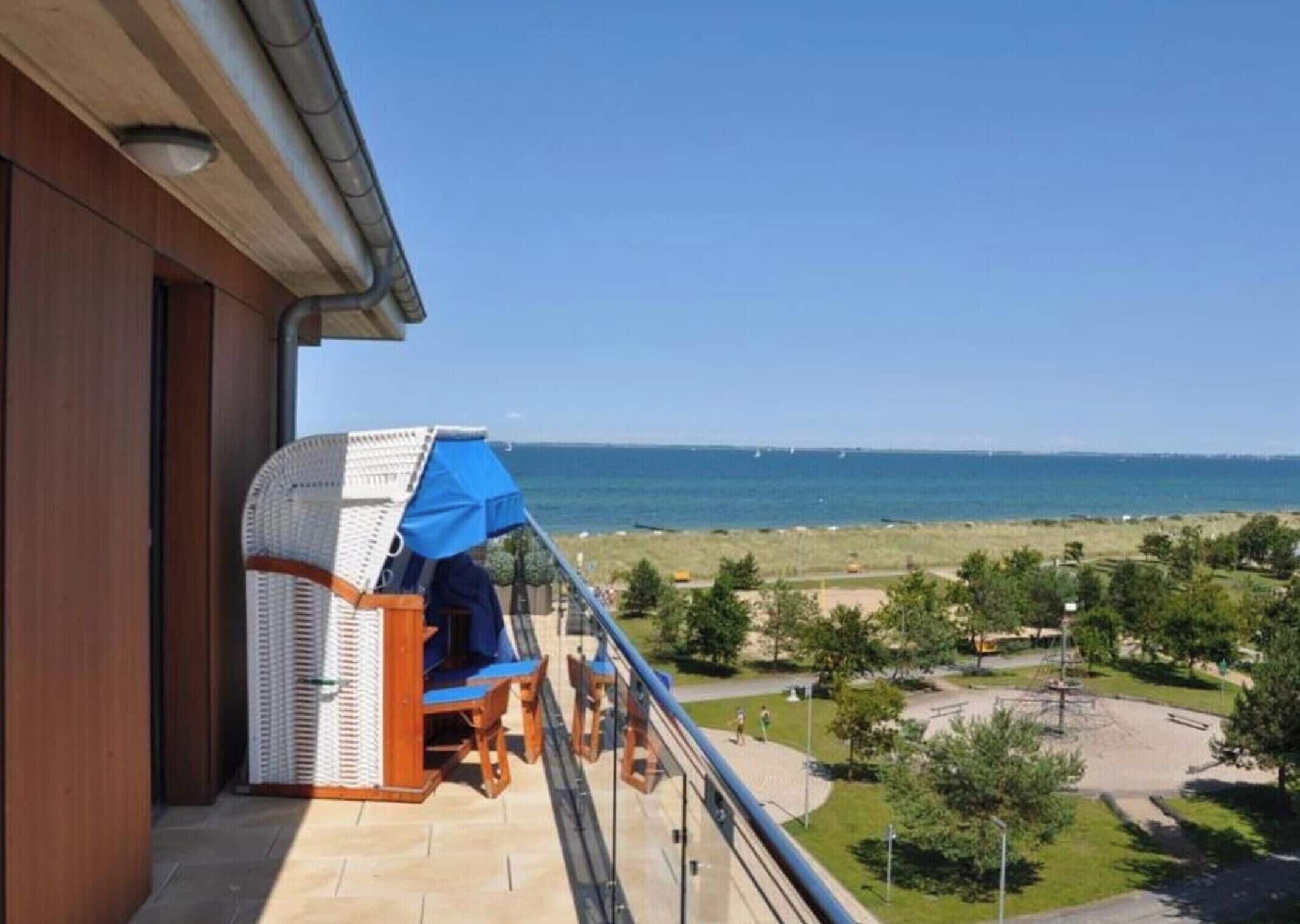 A balcony with a view of the sea and a beach.