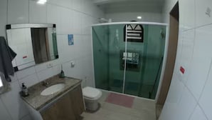 Une salle de bain équipée d’un lavabo, de toilettes et d’une douche à parois en verre.