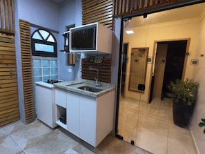 Uma cozinha compacta com fogão embutido, pia e uma bancada pequena.